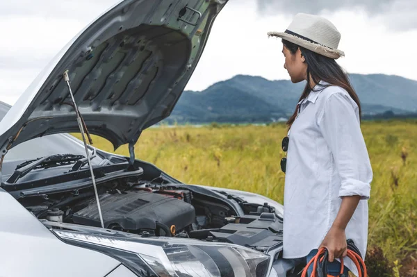 Asian woman holding battery booster cable copper wire for repair — 스톡 사진