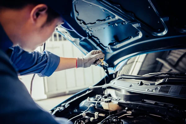 Car mechanic holding checking gear oil to maintenance vehicle by — 스톡 사진