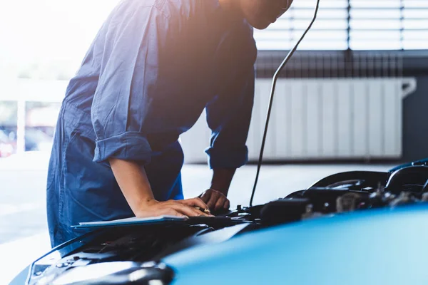 Mecánico de automóviles sujetando portapapeles y comprobando el mantenimiento vehic — Foto de Stock