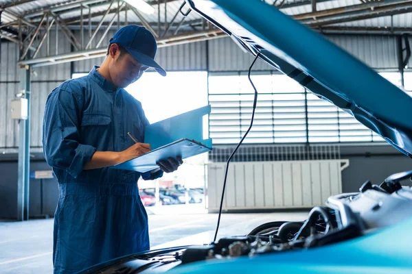 Kfz-Mechaniker hält Klemmbrett und überprüft Wartungsfahrzeug — Stockfoto