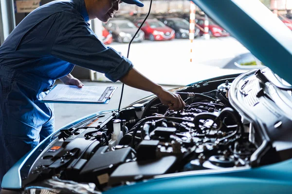 Mécanicien de voiture tenant presse-papiers et le contrôle de l'entretien vehic — Photo