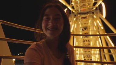 Lunaparktaki dönme dolabın içinde heyecanlı Asyalı kız. Güzellik kraliçesi şehrin en gözde gece etkinliklerinin keyfini çıkarıyor. İnsanların yaşam tarzları ve eğlence anlayışı. Seyahat tatil teması