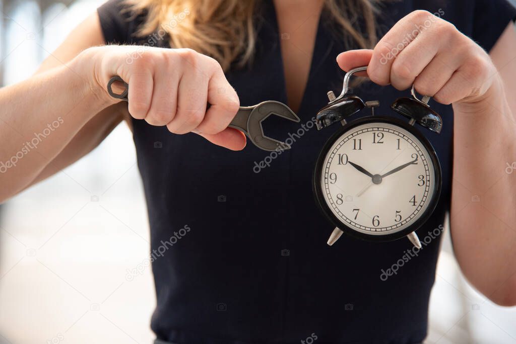 Business woman try to adjust time on alarm clock after shocked with late in rush hours when going to work in city urban background. Deadline and wake up late. People lifestyle daily life concept. 
