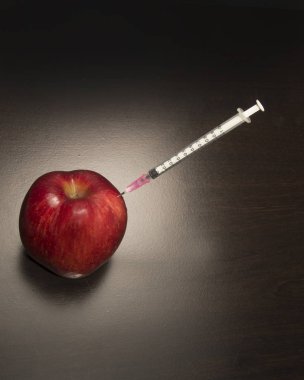 Kırmızı elma ve bir şırınga