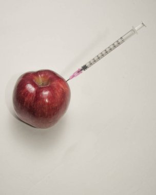 Kırmızı elma ve bir şırınga