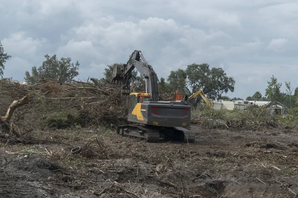 Máquinas de construção escova de limpeza e árvores em uma propriedade pr — Fotografia de Stock