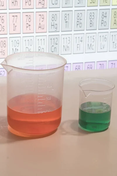 Sostanze chimiche in forma liquida a fini didattici con la tavola periodica  . — Foto Stock