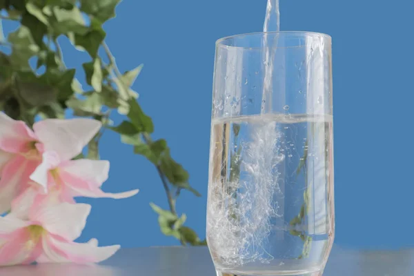 Agua refrescante se vierte en un vaso para asegurar la salud a — Foto de Stock