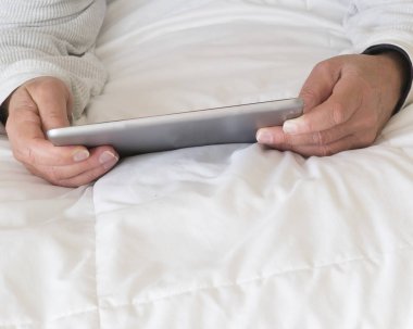 Yatakta bir kişi tarafından internet yayını ve bilgi için kullanılan bilgisayar yastığı .