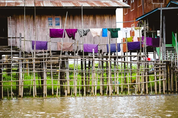 Traditional wooden houses on Inle lake with drying colorful clothes — Stock Photo, Image