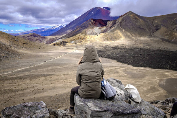 Woman hiker admiring volcanic landscape view of Tongariro, New Zealand