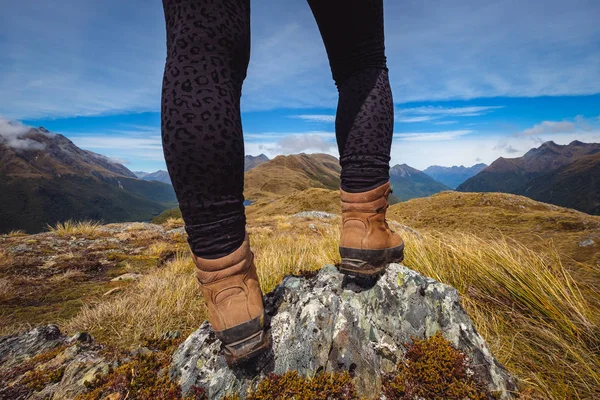 Detalhe das pernas da mulher em sapatos de trekking com fundo de gama de montanha — Fotografia de Stock