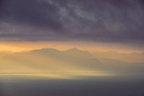 Vista dramática da paisagem do nascer do sol sobre as montanhas e o oceano — Fotografia de Stock