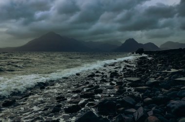 Dramatic landscape coastline view of rocks and Cullin hills, Scotland clipart