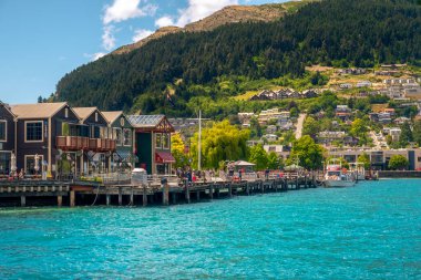 QUEENSTOWN, NEW ZEALAND - 13 HAZİRAN 2017: Güneşli bir günün tadını çıkaran göl, sokak evleri ve turistlerin manzarası, Queenstown, Yeni Zelanda