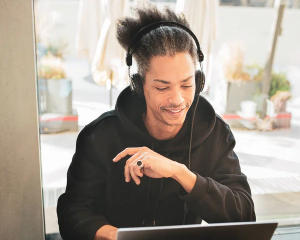 Creative afro american man, with weird hair, is studying and creating new content for his personal blog, latin american working on web project, lifestyle concept of blogger, influencer, smart working
