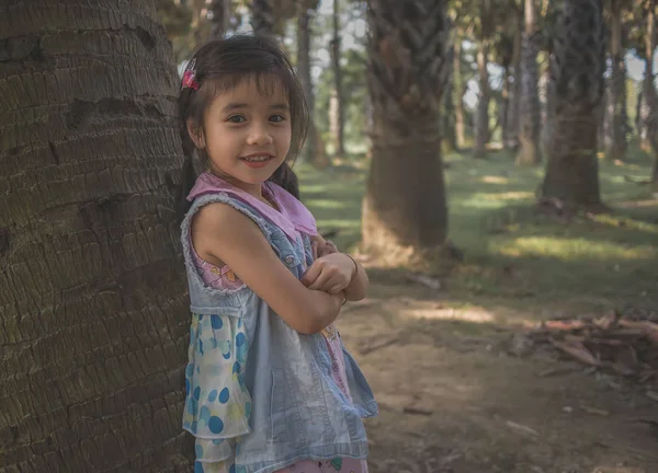 Маленькая Девочка Стоит Возле Пальмы — стоковое фото