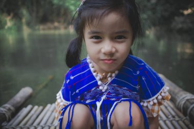 Küçük kız nehir kıyısındaki köprüde dinleniyor.