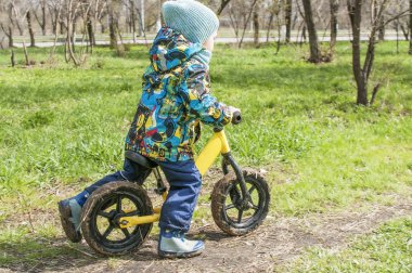 Küçük bir çocuk bir çocuk spor ve aktif bir yaşam tarzı, bir bisiklet sürme bir parkta motor, denge bisikleti çalıştırılsın mı
