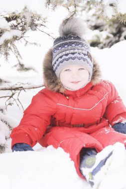 Bir çocuk kış giyim, kış parkın içinden bir yürüyüş portresi,