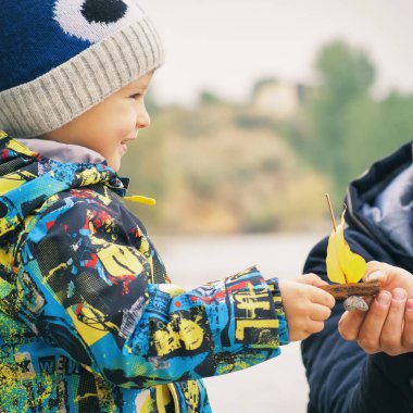 Baba ve oğul yapmak ve sonbahar yaprak, çocukluk, instagram etkisini yapılan bir tekne denize indirmek