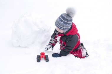 Bir çocuk bir kardan adam sokakta, bir çocuk bir kırmızı genel kışın sculpts