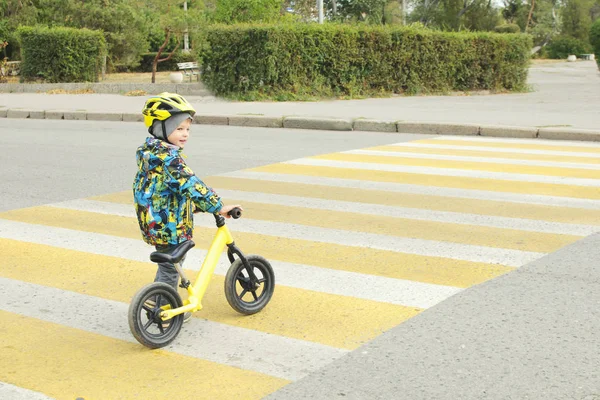 Bir çocuk bir bisiklet ile bir yaya geçidi ile sarı lekeler geçer