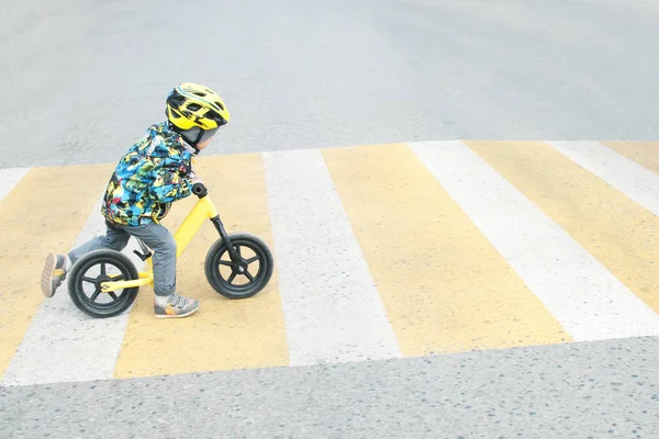 A boy with a bicycle crosses a pedestrian crossing with yellow markings — Stock Photo, Image