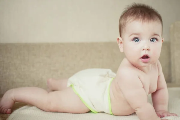 Uma criança pequena em fraldas de tecido natural, fraldas de algodão eco-friendly — Fotografia de Stock