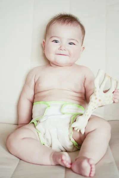 Un niño pequeño en pañales de tejido natural, pañales de algodón ecológicos —  Fotos de Stock