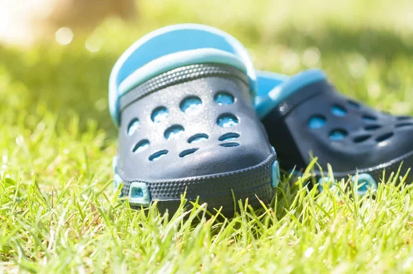 Дети синие тапочки на зеленой траве в саду, обувь для детей, пляжная мода для детей, концепция релаксации — стоковое фото