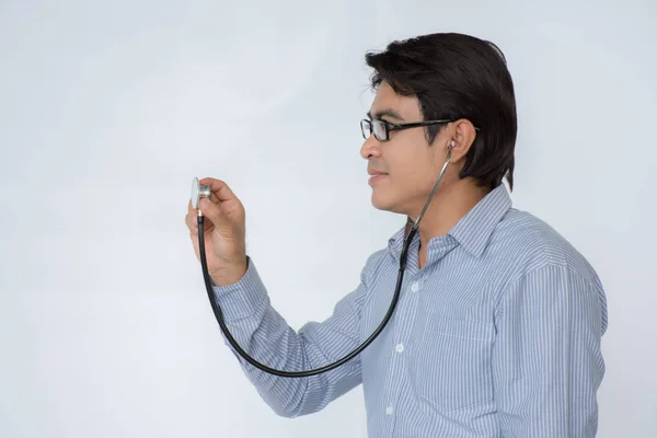 Доктор слухає серцебиття зі стетоскопом на білому тлі — стокове фото