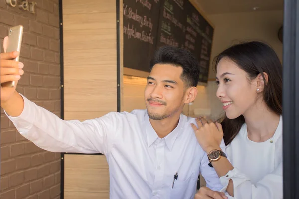 Two young Couple doing Take a photo yourself in a cafe