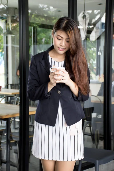 亚洲漂亮女孩抱着茶杯享受与休息时间在户外的咖啡厅. — 图库照片