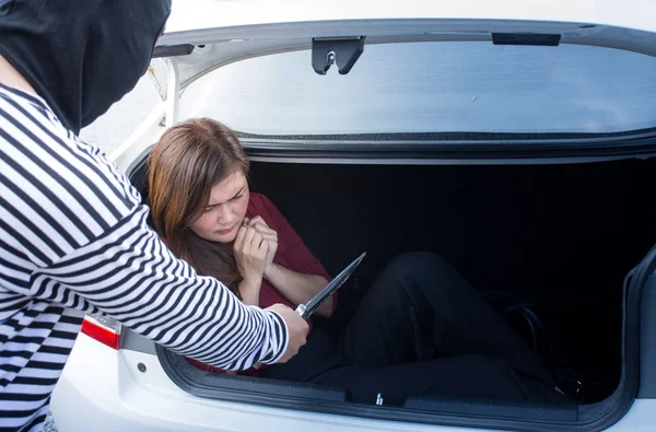 Kidnapped Asian woman. Tied up businesswoman lying in the car trunk and Scare