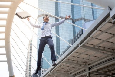 Havada atlama ve iş başarısı için silahlarla yükselterek komik neşeli işadamı