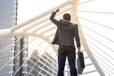 Evrak çantası ve silah kadar ayakta başarı için iş merkezinde tutarak Asya iş adamı