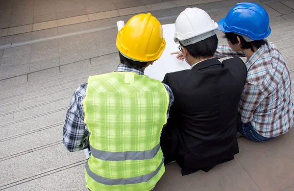 Tým inženýrů a foreman práci venku, diskutovat s plány projektů. — Stock fotografie