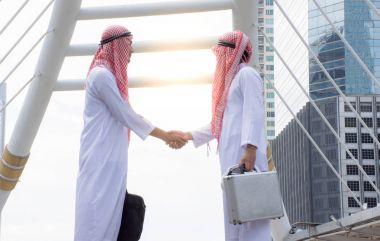 Başarı için bir anlaşma müzakere üzerinde el sıkışan Arap iş adamları