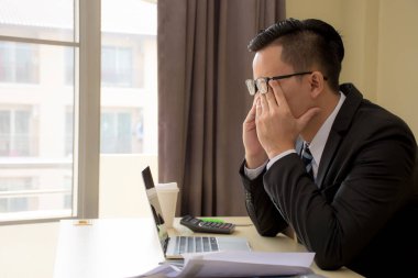 Yakışıklı genç Asyalı işadamı ile laptop ofisinde bardaklarda vurguladı