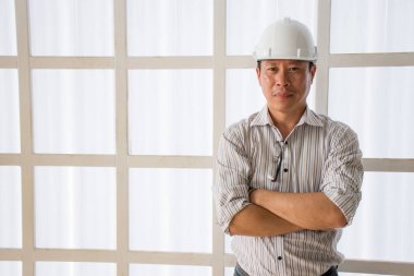 Profesyonel geçti ve beyaz duvara emin seyir giyen Emanet kask ayakta silah mühendislik Asya