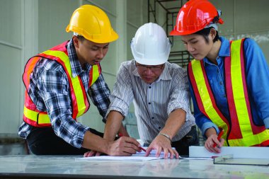 Grup mühendislik ekibi, buluşacak inşaat iş planlama, kağıt planları inşaat sahasında, havai görünümü, takım çalışması için kavram arıyor