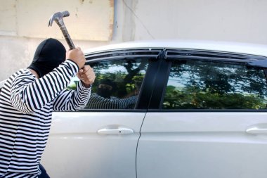 Adam hırsız bir yün kafasına çekiçle araba/seçici odak/ceza ve araba hırsız kavramı sızmak isteyen holding ile