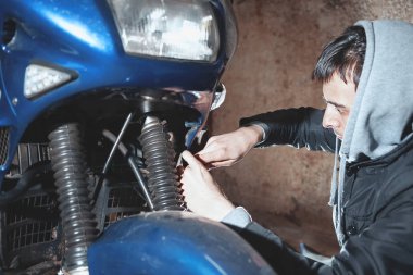 Adam onarım motosiklet garajda. yakın çekim