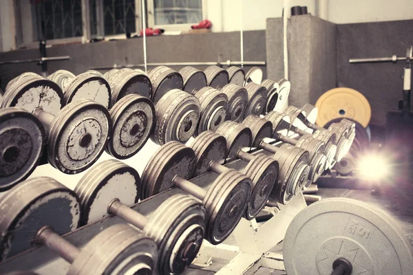 Eski dumbbells satırı. Eski püskü boya metalik gri. Spor salonu