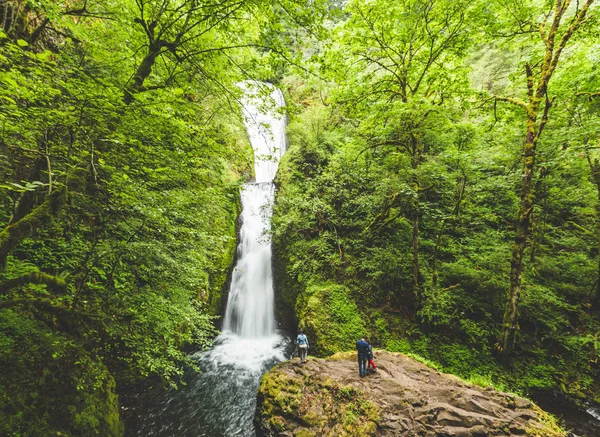 Люди, стоящие у водопада — стоковое фото