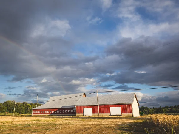 Gökkuşağı çiftlik arazi ile kırmızı ahır — Stok fotoğraf