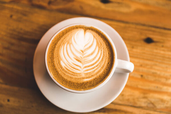 Perfect cappuccino in white cup on wood table