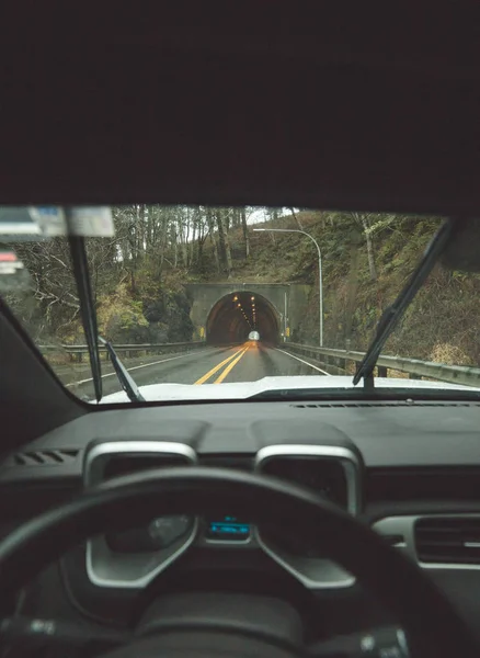 Driver 's point of view approaching tunnel in rainy coastal area — стоковое фото