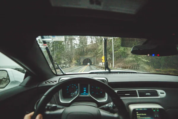 Driver 's point of view approaching tunnel in rainy coastal area — стоковое фото